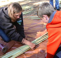 mother and son tying sticks together