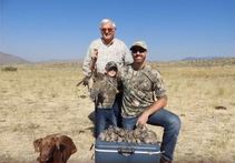 Three Generations of Hunters and chocolate lab pose with dove limit on cooler
