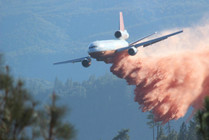 Airplane dropping fire retardant.