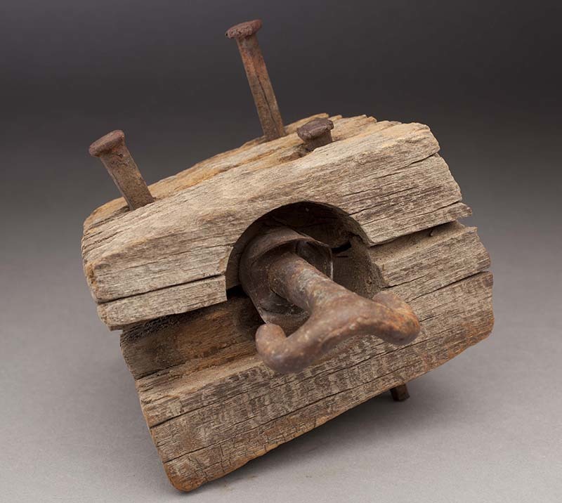 Rams horn-style insulator made of a wooden block, so named because of its shape.
