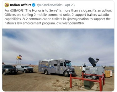 A police van parked in a dirt lot.