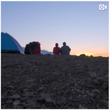 Video still of camper watching a sunset.