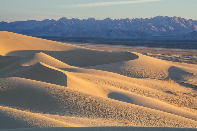 Sand dunes with mountains in the background.