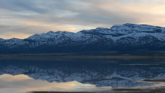 Snowy mountain range with a lake in the foreground.