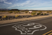 A roadway that says Route 66 with a mountain in the background.