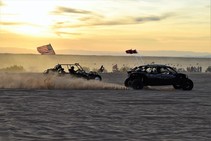 Two off road vehicles racing in the sand.