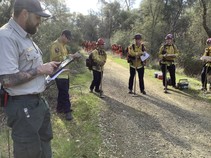 A group of firefighters stand for a briefing.