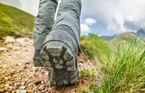 Close up of someone's boots as they are walking on a trail.