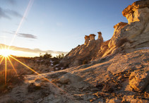 Natural rock formations in front of a sunset.