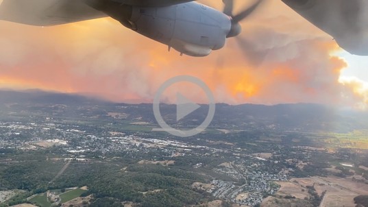 Underside of a plane flying over wildfires
