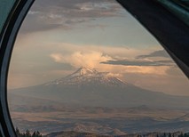 A mountain view through a tent door.