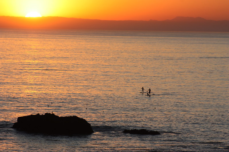 Two friends paddleboard at Laguna Beach with a dog enjoying the water and sunset. Photo by Tracy Albrecht, BLM.