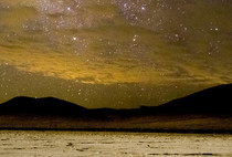Galactic Core over Soda Lake: dry lake bed with hills silhouetted in the background. 