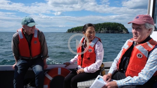Secretary Haaland sits in a boat with two other people