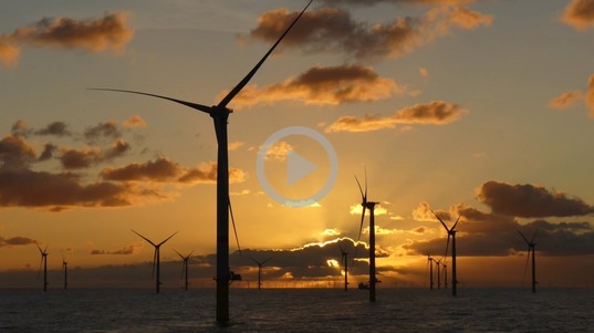 A wind turbine with a sunset in the background