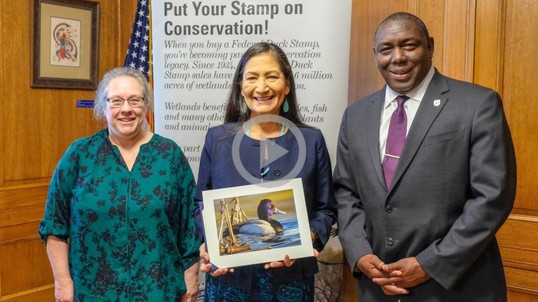 Secretary Haaland stands with the new duck stamp