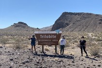 Three ladies standing by a BLM sig in the desert.