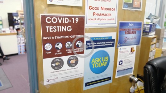 A bulletin board is covered in signs about COVID testing