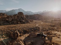 View of Alabama Hills with trail winding towards rocky features and pickup with tent in foreground. Photo_The Dyrt