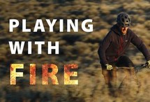 A mountain biker with a graphic that reads playing with fire.