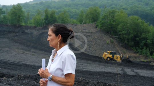 Secretary Haaland with construction equipment in the background.