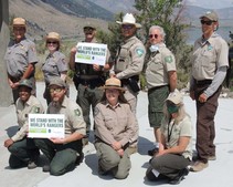 Park rangers stand together representing NPS, BLM, USFS, CA State Parks holding signs, We Stand with the World's Rangers