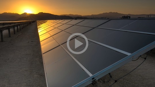 Solar panels reflect the light from a distant sunset
