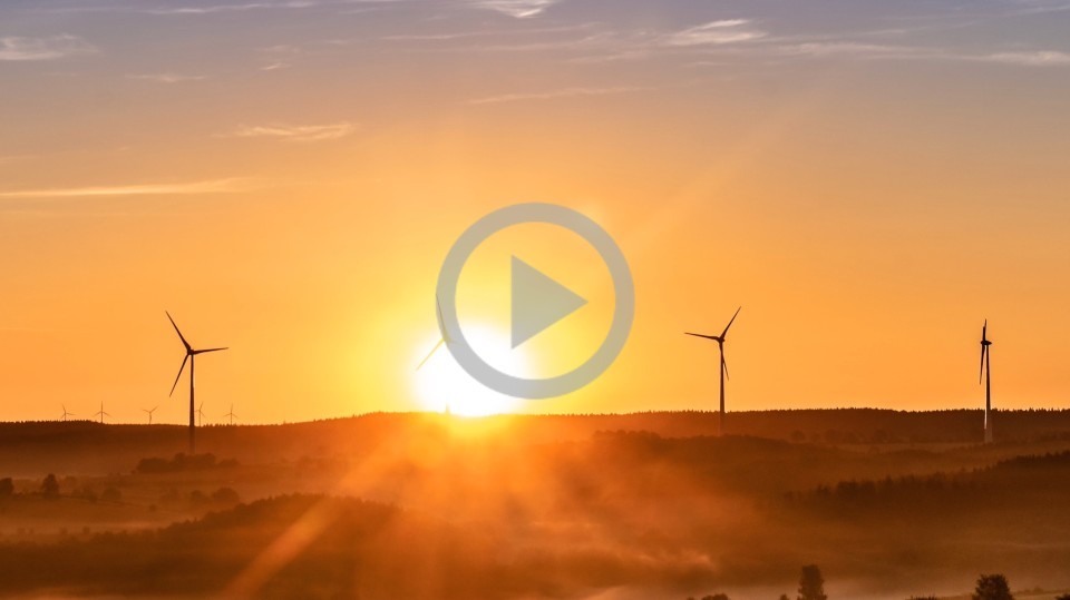 Wind turbines on a distant hill while the sun sets