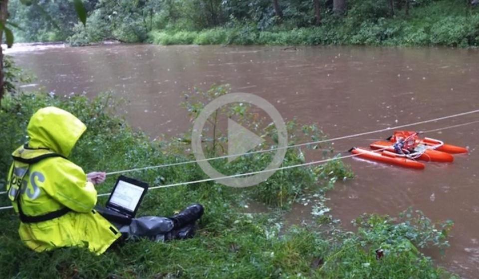A USGS scientist takes stream measurements during a flood