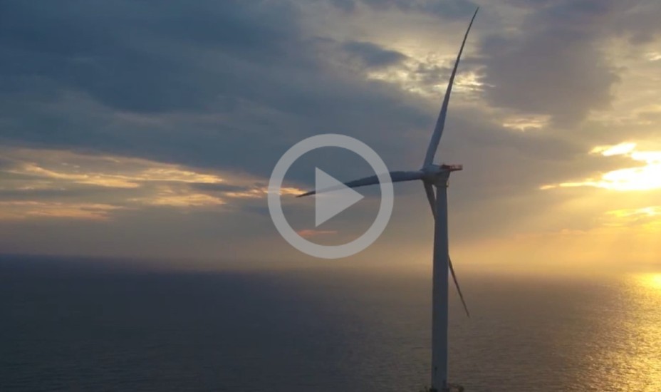 Wind turbines in the ocean with a sunset background