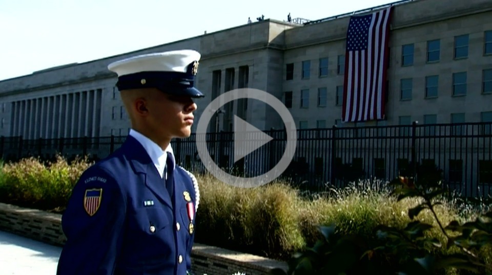 A marine in their dress uniform stands at a 9/11 ceremony