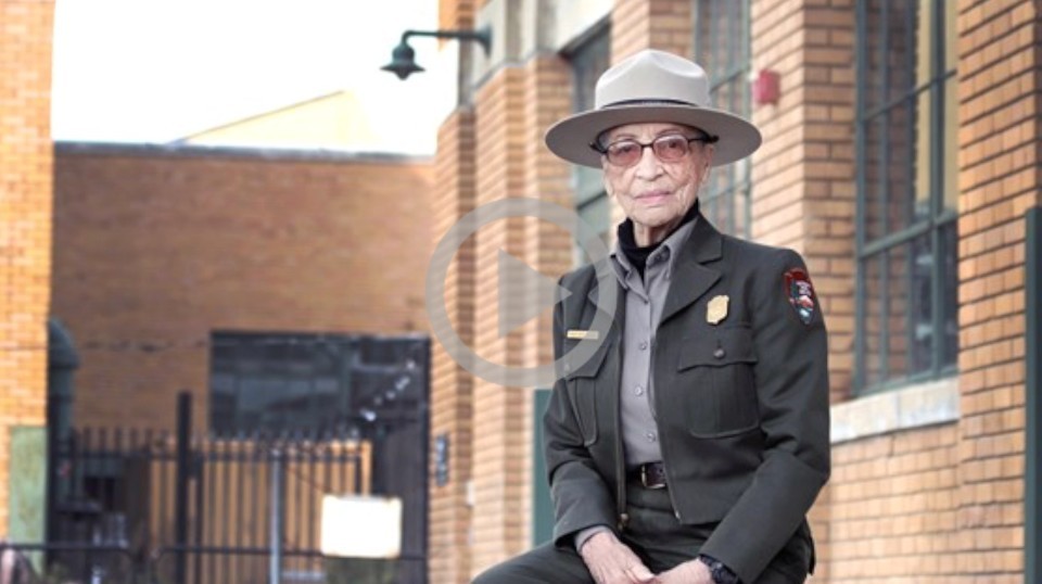 Ranger Betty sits on a concrete block while dressed in her dress ranger uniform