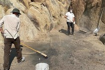 BLM and volunteers working to clean up illegal fire rings amongst rocks.