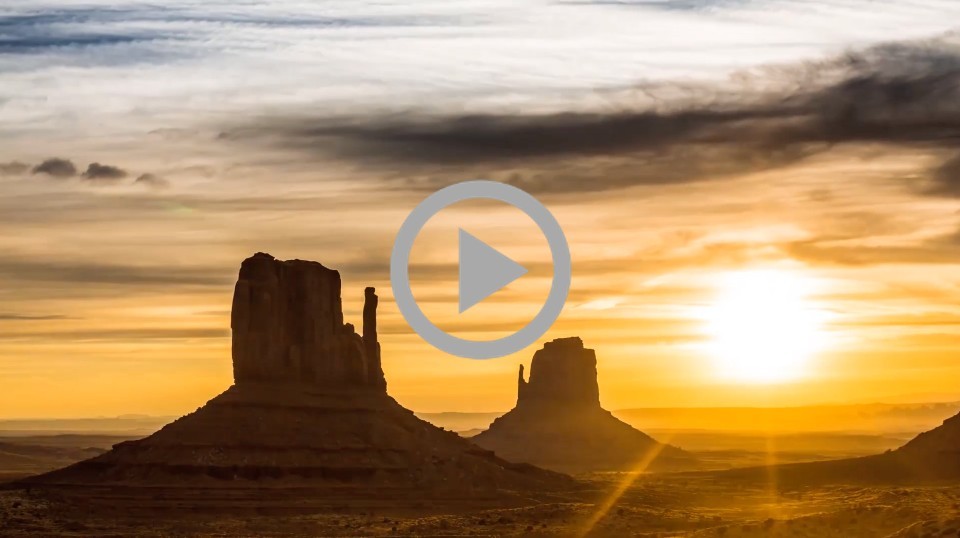 A sunrise over buttes in the desert