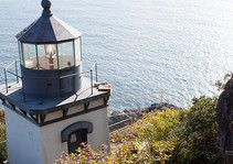 A small one story building lighthouse, with a lantern room on top, overlooking the ocean from 380 feet above the water. 