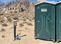 Porta-potties in front of a mountain.