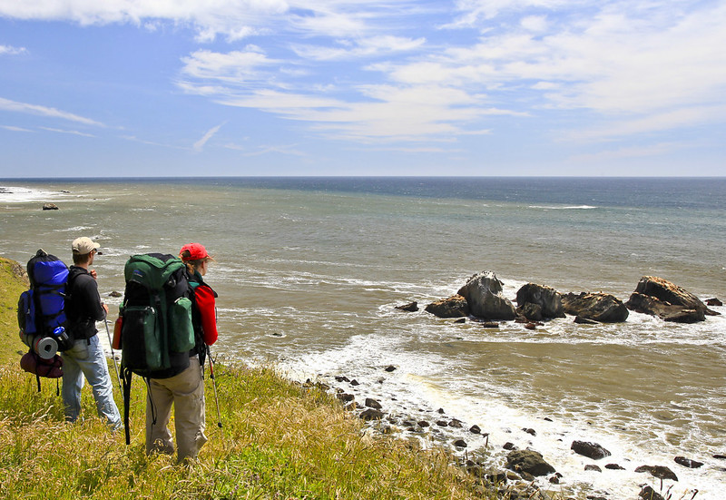 Two hikers stand on the coast at King Range National Conservation Area.
