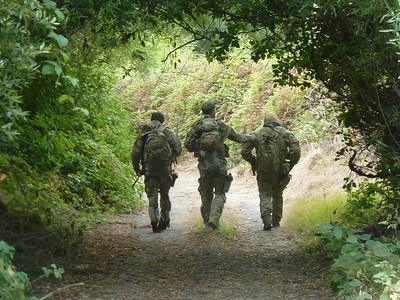 Three rangers walking on a trail.