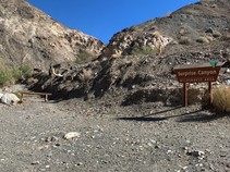 A rocky parking area in front of a sign that reads Surprise Canyon Wilderness Area.