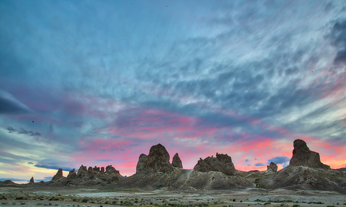 Tall rock formations with a pink sunset behind them.