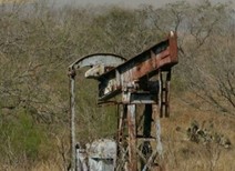 An oil derrick in a field.