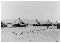 An old photo of tents in a desert.