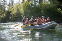 Many people in a raft on a river.