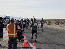Runners on a street in the desert.