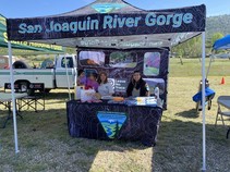 People sitting at a booth with a sign that reads San Joaquin River Gorge.