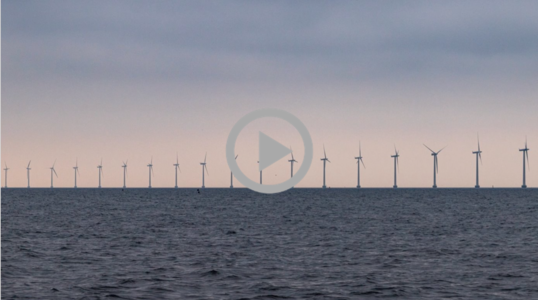 a row of wind ocean turbines against the sky  