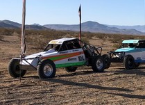 Race cars lined up in the desert.