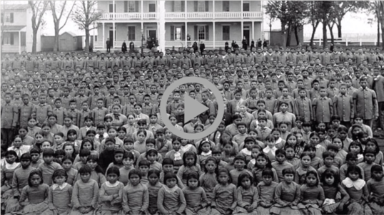  Historical photo of Indigenous children gathered outside a boarding school  
