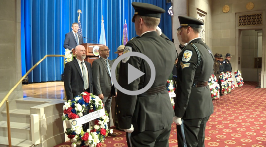 Uniformed officers salute wreath honoring fallen officers 