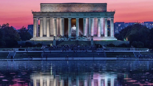 Visitors crowd the Lincoln Memorial and Reflecting Pool at sunset